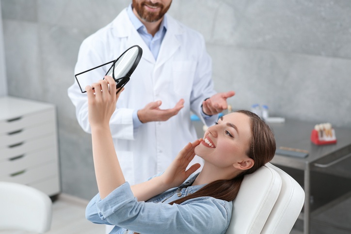 A Woman looking at her new All-On-Four Dental Implants in Brecksville & nearby areas